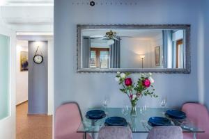 San Nicolas Apartment في أليكانتي: غرفة طعام مع طاولة مع كراسي أرجوانية ومرآة