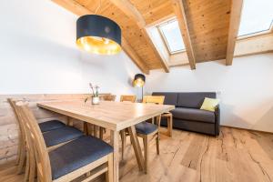 ein Esszimmer mit einem Holztisch und Stühlen in der Unterkunft Rauchenbichlerhof in Bruneck