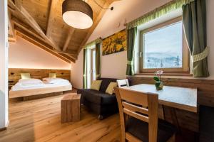 a room with a bed and a desk in a room at Rauchenbichlerhof in Brunico