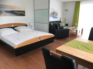 シュタインにあるSteiner Strandappartements Appartement 210 Südseite mit seitlichem Meerblickのベッドルーム1室(ベッド1台付)、リビングルームが備わります。