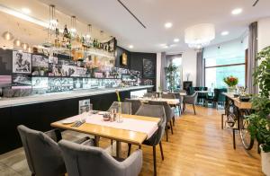 un restaurante con mesas y sillas y un bar en Hotel Troja en Praga