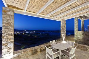 a patio with a table and chairs and a large window at Serifos Blue in Rámos