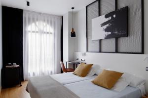 1 dormitorio con cama blanca y ventana en Hotel Marqués, Blue Hoteles, en Gijón