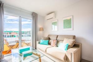 a living room with a couch and a glass table at Divina Home Apartments in La Cala de Mijas