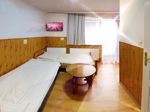 プシェシェカにあるOśrodek Wczasowy Zielona Gospodaのベッド2台とテーブルが備わる客室です。