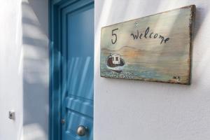 a sign that says welcome next to a door at Serifos Blue in Rámos
