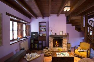 sala de estar con paredes de color púrpura y chimenea en Casas Rurales Pandesiertos, en Cangas de Onís
