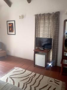 a living room with a flat screen tv on a stand at Chaminuka Lodge in Lusaka