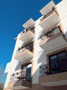 a white building with balconies and flowers on it at Suites Santiago in Santiago