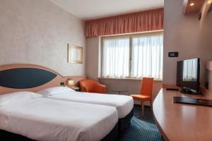 En eller flere senge i et værelse på Augustus Hotel