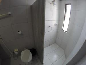 a bathroom with a shower with a toilet and a window at Iracema Mar Hotel in Fortaleza