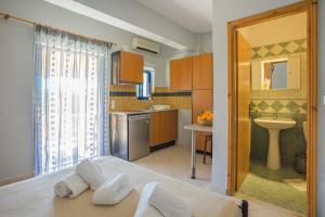 a kitchen with a bed and a sink in a room at Orange Apartments in Vasiliki