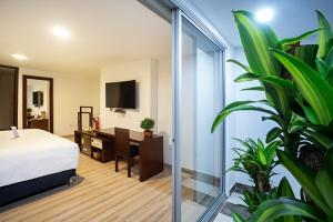 sypialnia z łóżkiem, biurkiem i telewizorem w obiekcie Loft Hotel Ipiales w mieście Ipiales