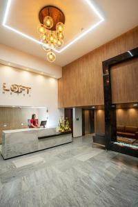 un vestíbulo con una mujer sentada en recepción en Loft Hotel Ipiales, en Ipiales