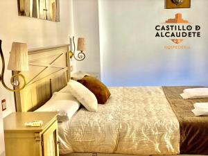 1 dormitorio con 1 cama y un cartel en la pared en HOSPEDERÍA CASTILLO DE ALCAUDETE, en Alcaudete