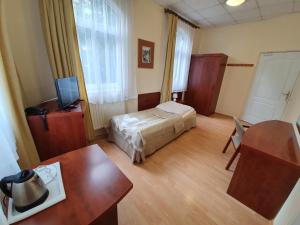 a hotel room with a bed and a table and a desk at Jantar in Polanica-Zdrój