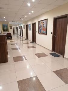 un corridoio di un edificio adibito a uffici con un ampio pavimento piastrellato di Hotel Lago Peshtera a Peštera