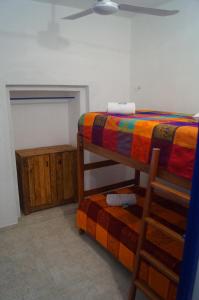 1 dormitorio con litera y silla de madera en Hostal Las Cruces, en Valladolid