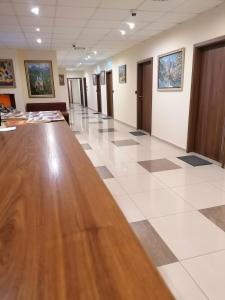 un grand couloir avec une grande table en bois dans un bâtiment dans l'établissement Hotel Lago Peshtera, à Pechtera