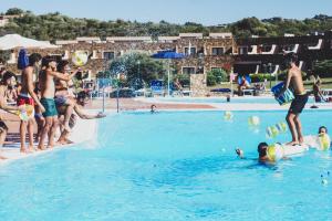 um grupo de pessoas na água em uma piscina em Residence Hotel Nuraghe em Porto Rotondo