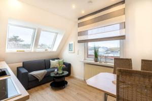 a living room with a couch and a table at Strandfliederhaus in Norderney