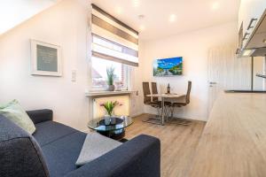 a living room with a couch and a table at Strandfliederhaus in Norderney