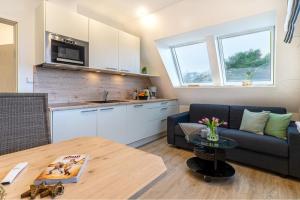 a living room with a couch and a table at Strandfliederhaus in Norderney