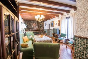 sala de estar con sillas verdes y mesa en tuGuest Country House Monachil, en Granada