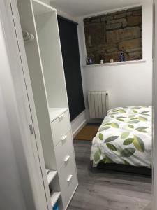 ein Schlafzimmer mit einem Bett und einem weißen Schrank in der Unterkunft Daisy Cottage in Saint Monance