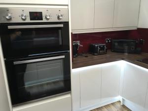 a kitchen with a black oven and white cabinets at Highland Escape in Fort William
