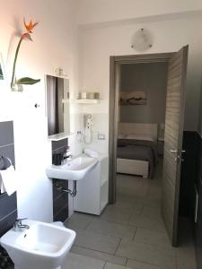 a bathroom with two sinks and a bed at La Scogliera in Avola
