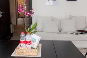 a table with two bottles of coca cola and flowers at NIU LUX Apartments in Genoa