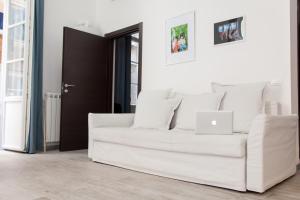 a white couch in a living room with a laptop at NIU LUX Apartments in Genova