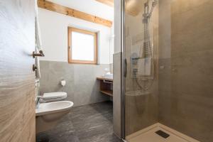 a bathroom with a shower and a toilet and a sink at Rauchenbichlerhof in Brunico +15 photos