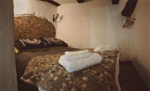 Una habitación con una cama con dos toallas. en La grotta del ghetto, en Pitigliano