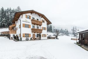 un bâtiment avec de la neige au sol dans l'établissement Rauchenbichlerhof, à Brunico