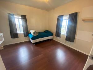 a small room with a bed and two windows at WHOLE Family - WholeVille in Sacramento