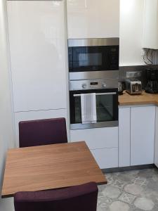 eine Küche mit einem Holztisch und einer Mikrowelle in der Unterkunft Calme et au cœur du centre historique in Bourges