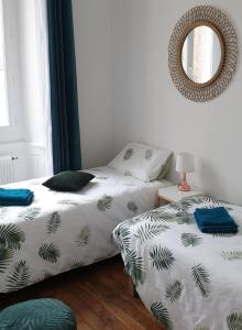 1 dormitorio con 2 camas y espejo en Calme et au cœur du centre historique en Bourges