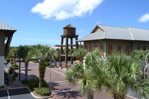 a building with a clock tower and palm trees at Redfish Village Condos in Santa Rosa Beach