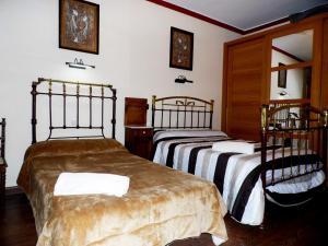 2 letti in una camera con pareti bianche di Casa Rural El Rincon del Infante a Villa de Don Fadrique