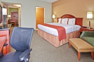 a hotel room with a large bed and a chair at Holiday Inn Memphis-University of Memphis, an IHG Hotel in Memphis