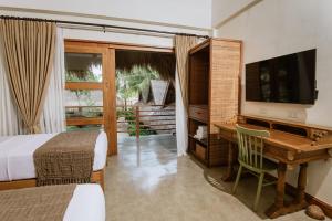a living room with a tv and a chair at Las Palmas Villas and Casitas Siargao in General Luna
