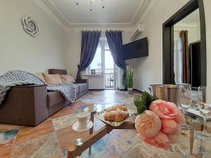 ein Wohnzimmer mit einem Sofa und einem Tisch mit Essen in der Unterkunft Inn Home Apartments - Kreshchatyk area in Kiew