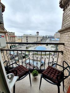 een balkon met 2 stoelen en uitzicht op een zwembad bij Inn Home Apartments - Kreshchatyk area in Kiev