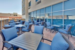 un patio con mesas y sillas en un edificio en Holiday Inn Express & Suites Plano East - Richardson, an IHG Hotel, en Plano