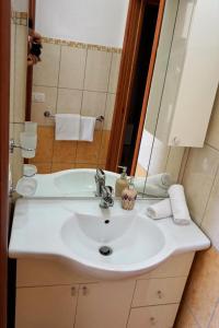 uma casa de banho com um lavatório branco e um espelho. em Central House em Realmonte