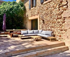 un divano seduto su un patio accanto a un edificio in pietra di La Forge a Montséret