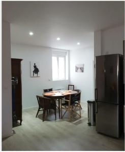 een eetkamer met een tafel en een koelkast bij Appartement hyper-centre Epernay avec sauna et parking privé in Épernay