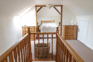 LlwyngwrilにあるBryntegのベッドルーム1室(ベッド1台付)、木製の階段